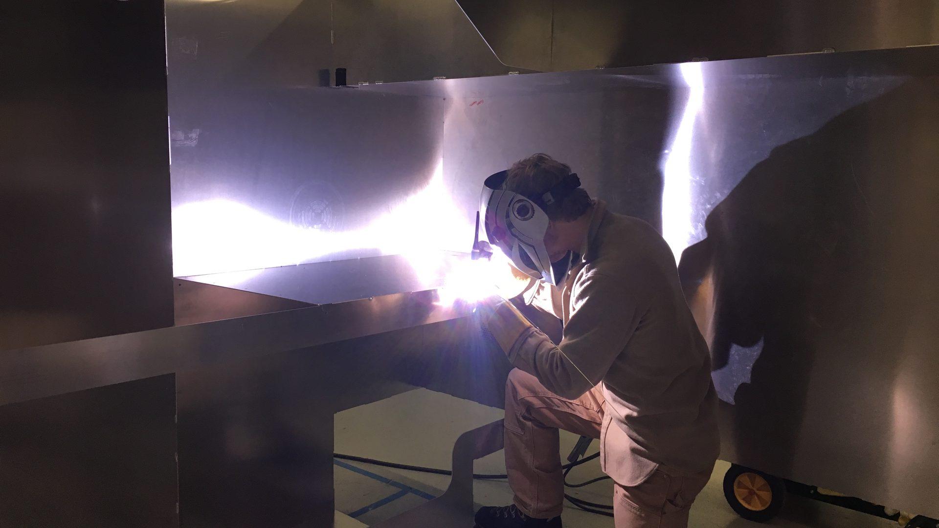 Kimbo Living founder Mark King welding the interior of an early Kimbo aluminum truck bed camper prototype at the Bellingham, Washington workshop.